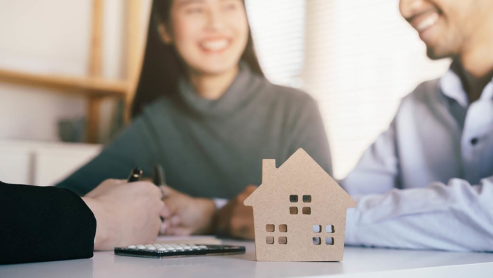 Home buyers with a real estate agent signing a contract Home buyers with a real estate agent signing a contract