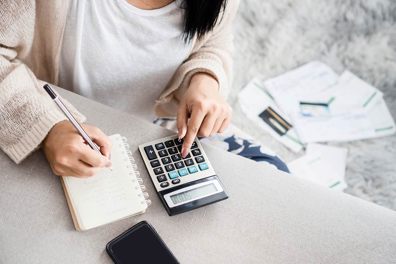 Image of a woman using a calculator to figure out personal finances