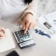 Image of a woman using a calculator to figure out personal finances