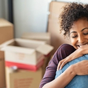 Woman holding keys from new home and embracing man