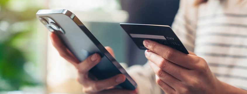 Woman hand holding credit cards and using smartphone for shopping online with payment on internet banking