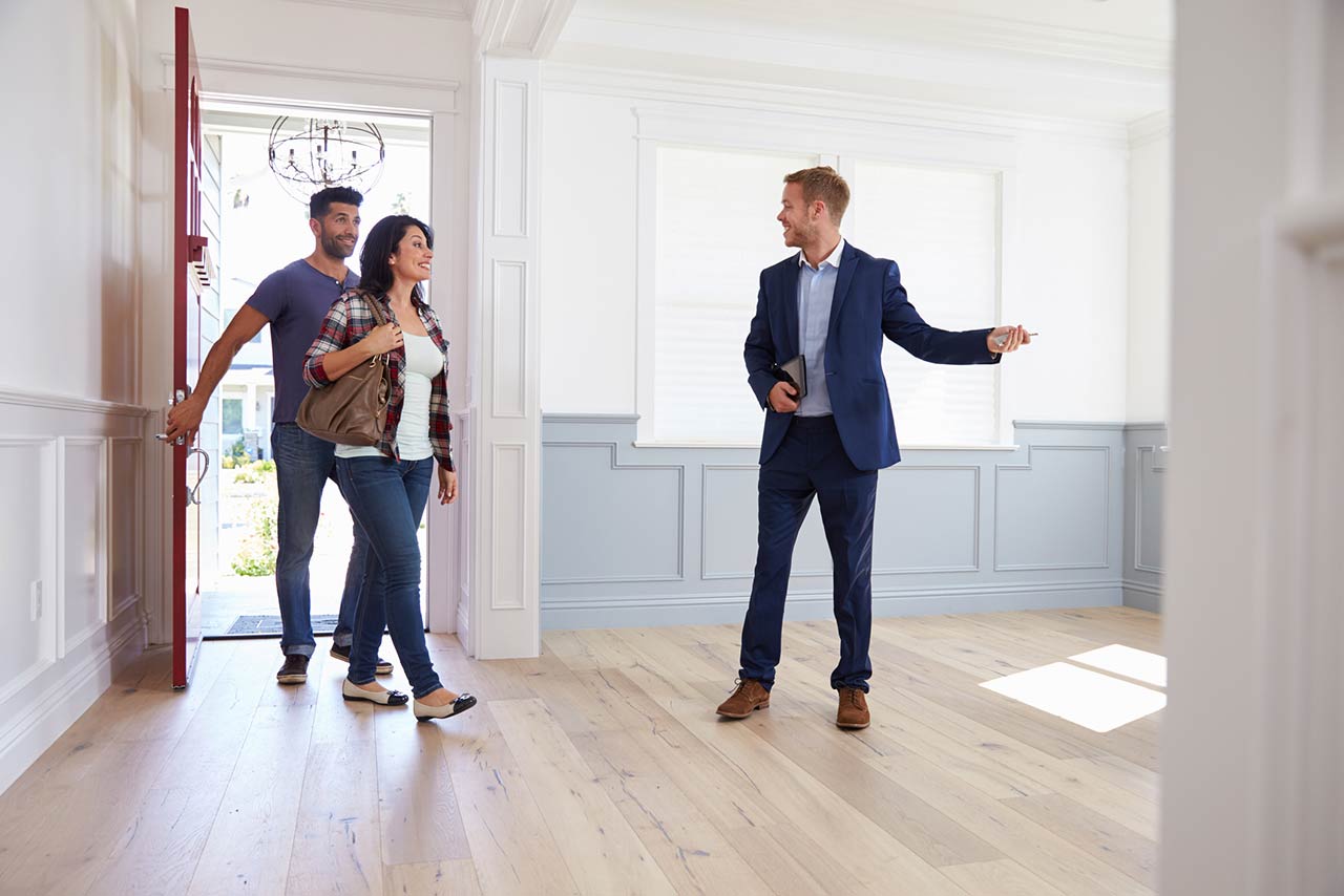 Real estate agent showing a couple around new home