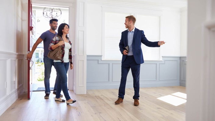 Real estate agent showing a couple around new home Real estate agent showing a couple around new home