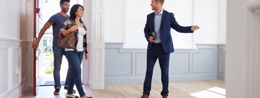 Real estate agent showing a couple around new home