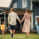 Young couple walking towards a country house with their two children