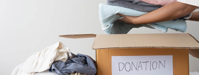 woman hands holding clothes putting in a donation box