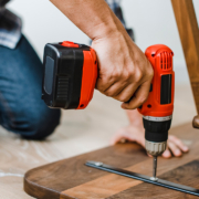 Man using hand drill to assemble a wooden table