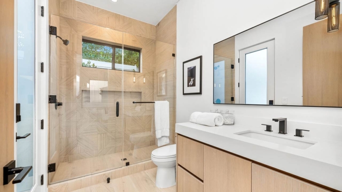 Modern bathroom with glass shower, wooden cabinets, and sleek fixtures in a bright, minimalist design Modern bathroom with glass shower, wooden cabinets, and sleek fixtures in a bright, minimalist design